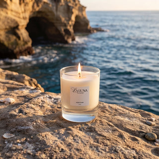 Panel 1: Lit Laguna candle placed on a natural rock surface beside the ocean, with a coastal cliff and calm sea in the background.